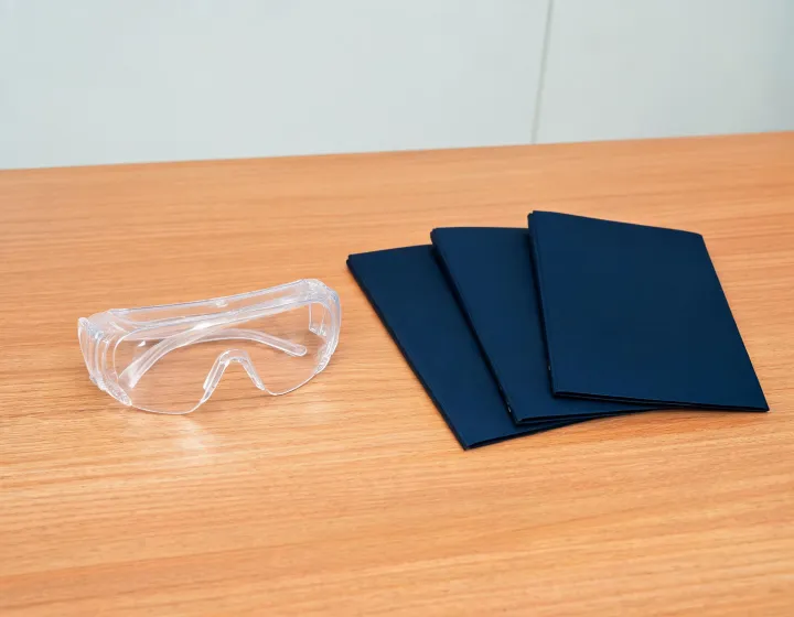 Mens clear safety glasses brief beside factory quote folders